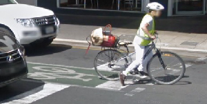 Cyclist at the traffic lights in-between two cars showing the cycling infrastructure